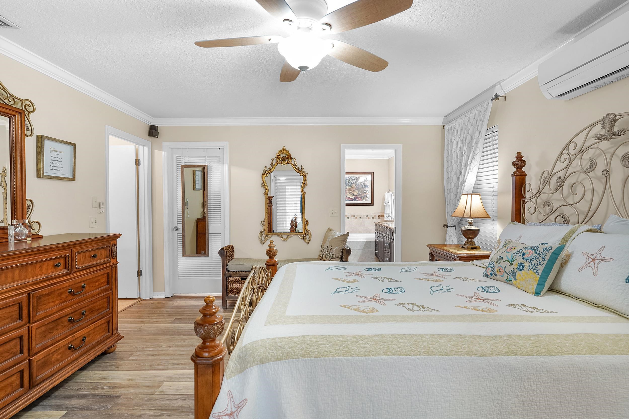 4 Calusa Court Palm Coast, FL 32137 - Photo 20 of 51 Bedroom featuring a wall unit AC, ornamental molding, ceiling fan, light wood finished floors, and connected bathroom