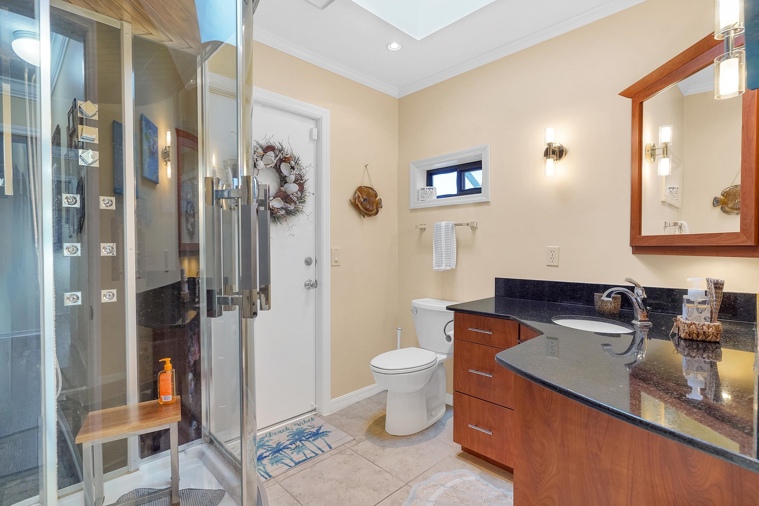 4 Calusa Court Palm Coast, FL 32137 - Photo 30 of 51 Bathroom with vanity, light tile patterned floors, ornamental molding, a skylight, and a stall shower