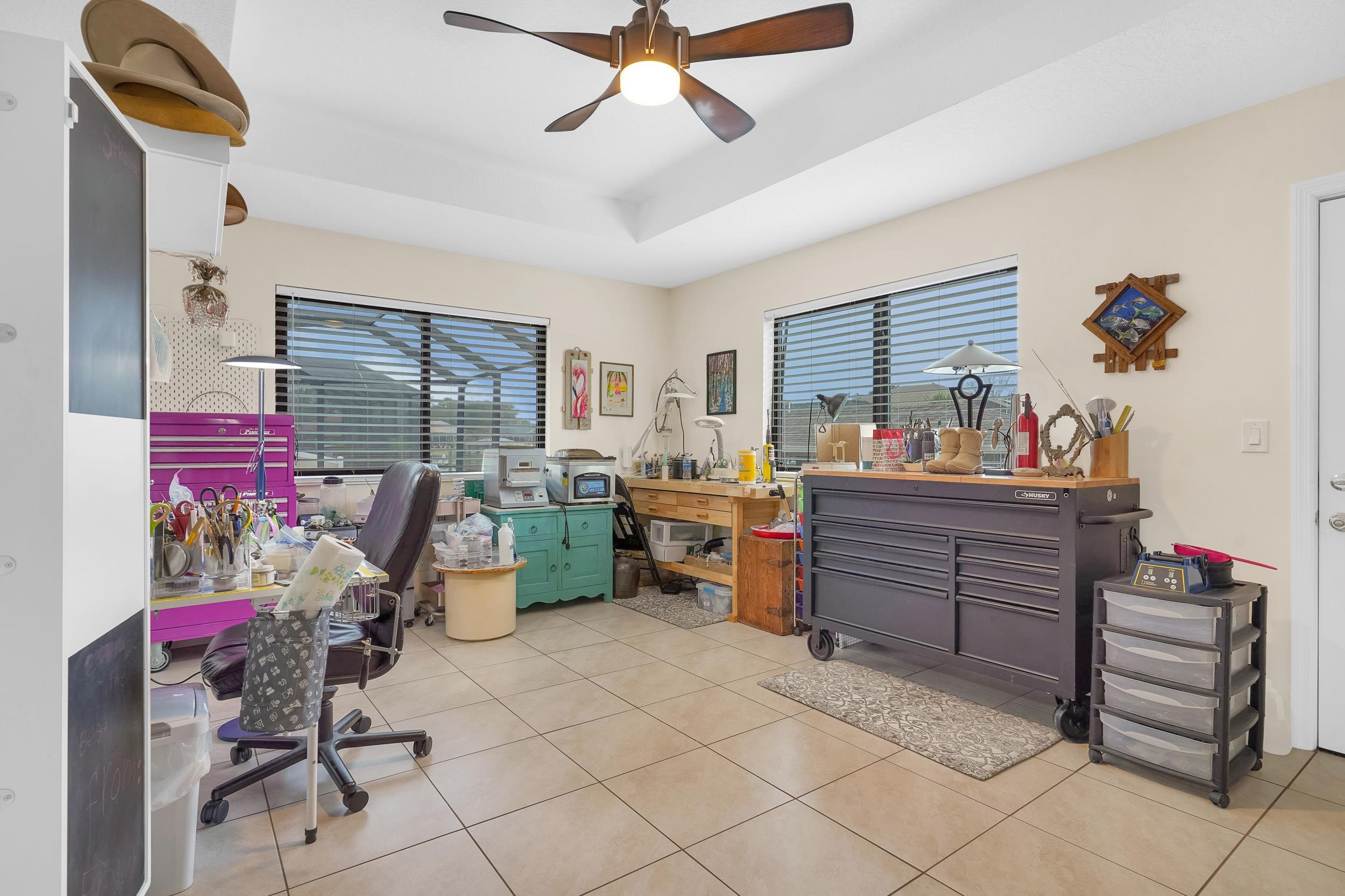 4 Calusa Court Palm Coast, FL 32137 - Photo 33 of 51 Office space with healthy amount of natural light, light tile patterned flooring, a ceiling fan, and a workshop area