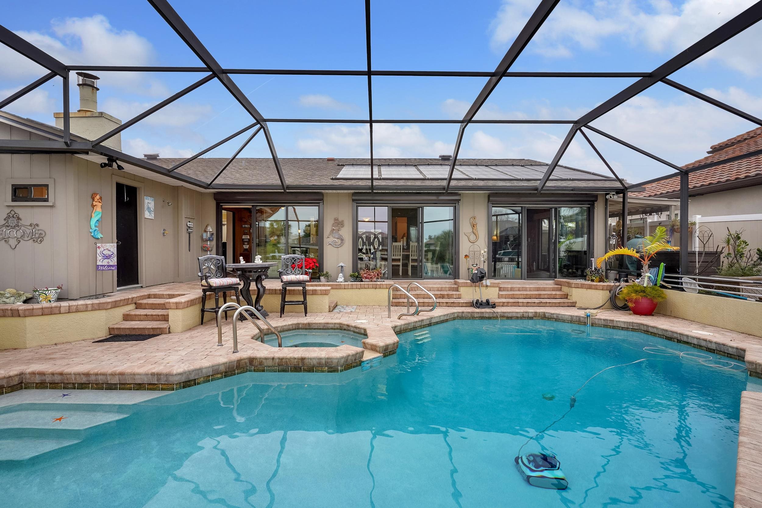 4 Calusa Court Palm Coast, FL 32137 - Photo 37 of 51 View of swimming pool with glass enclosure, a sunroom, and a patio area