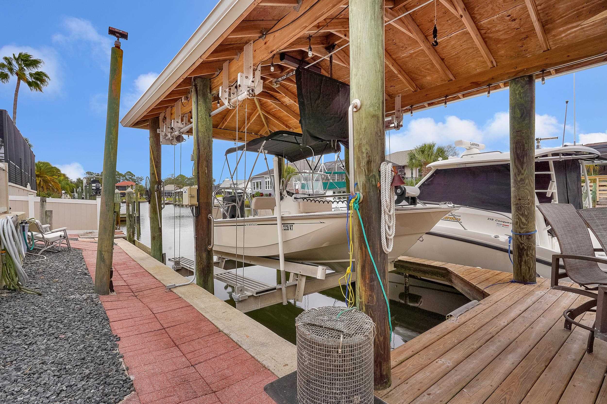 4 Calusa Court Palm Coast, FL 32137 - Photo 41 of 51 Dock featuring boat lift and a water view