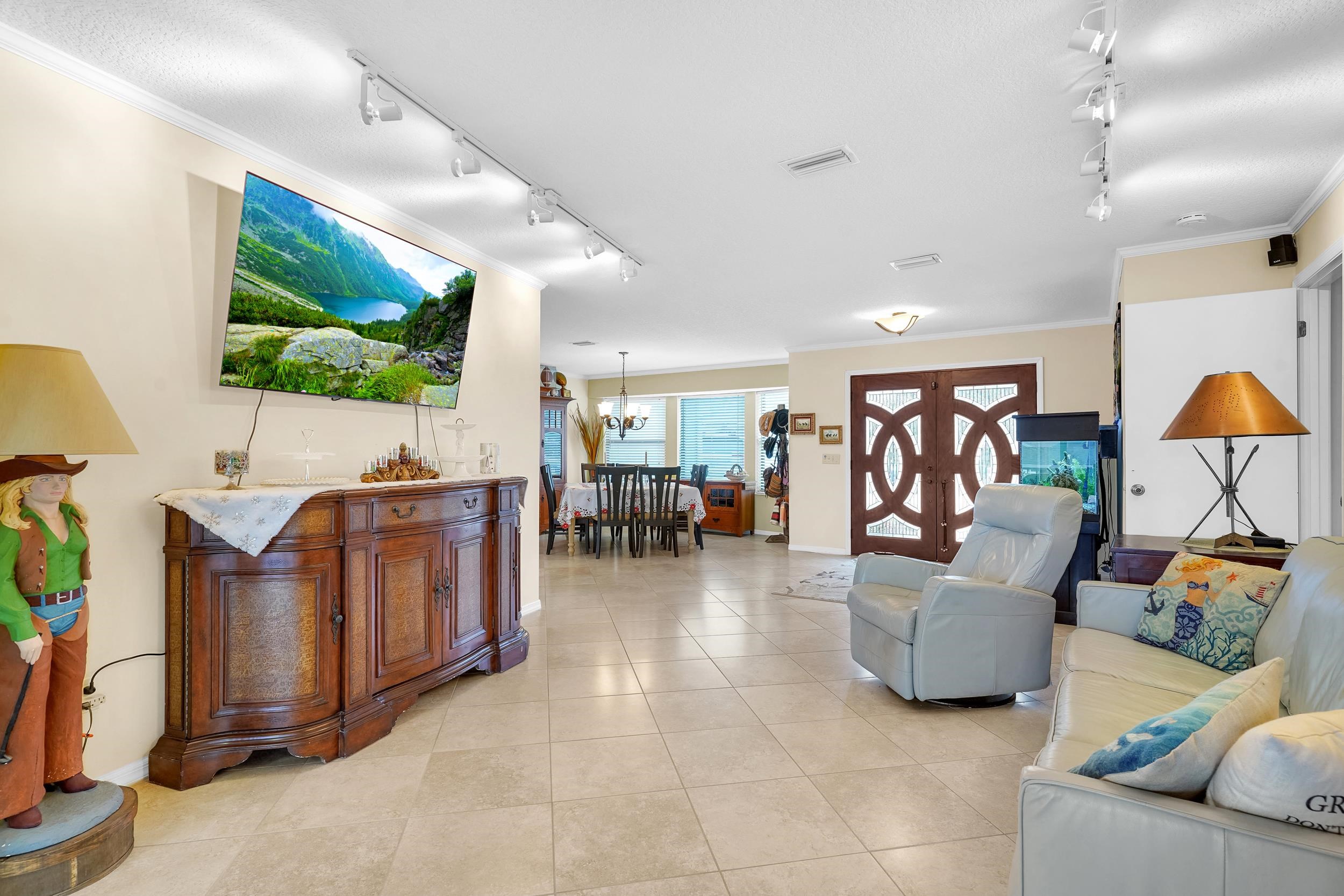 4 Calusa Court Palm Coast, FL 32137 - Photo 6 of 51 Living room with ornamental molding, rail lighting, light tile patterned floors, and a chandelier