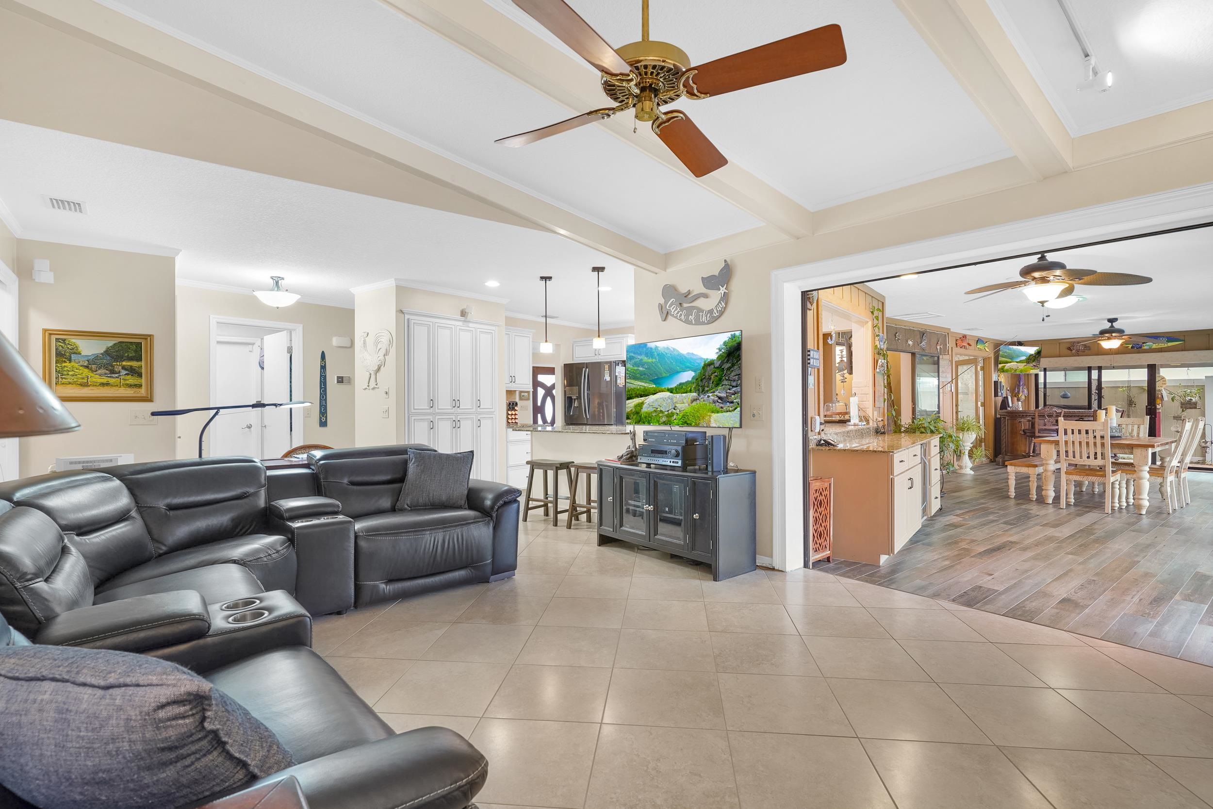 4 Calusa Court Palm Coast, FL 32137 - Photo 9 of 51 Living room featuring a ceiling fan, light tile patterned floors, and beamed ceiling