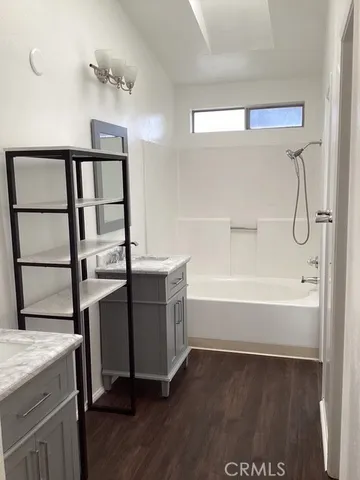a bathroom with a tub a sink and a window