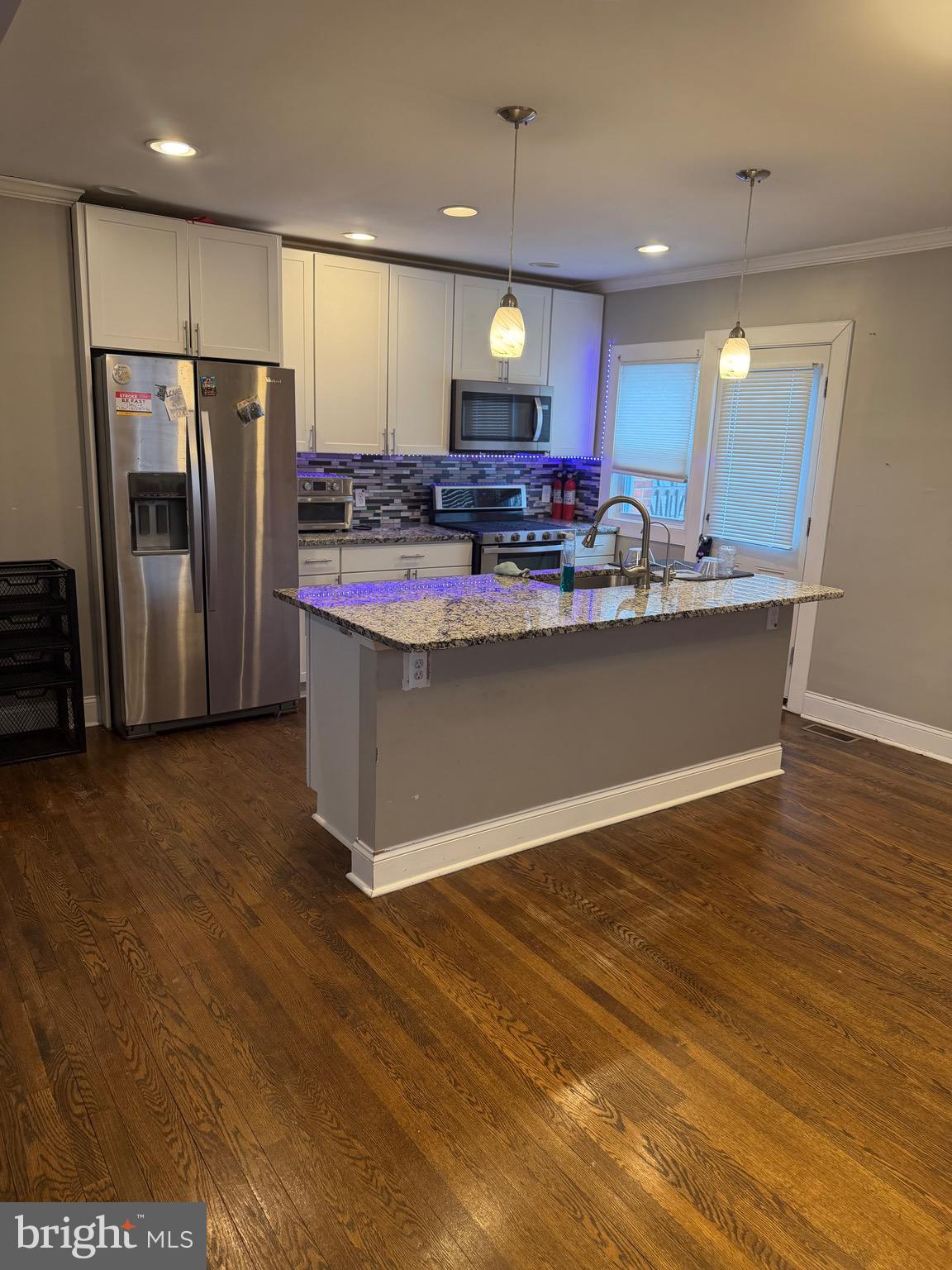 a view of kitchen with refrigerator stove microwave and cabinets
