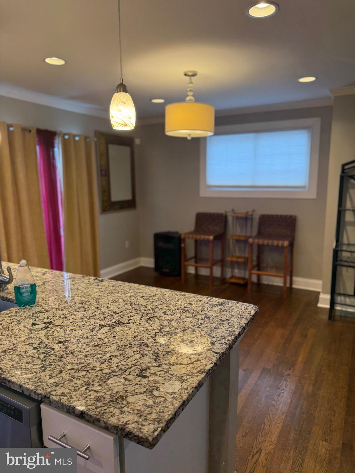 4814 Coleherne Road Baltimore, MD 21229 - Photo 3 of 8 a kitchen with kitchen island granite countertop wooden cabinets and a granite counter tops