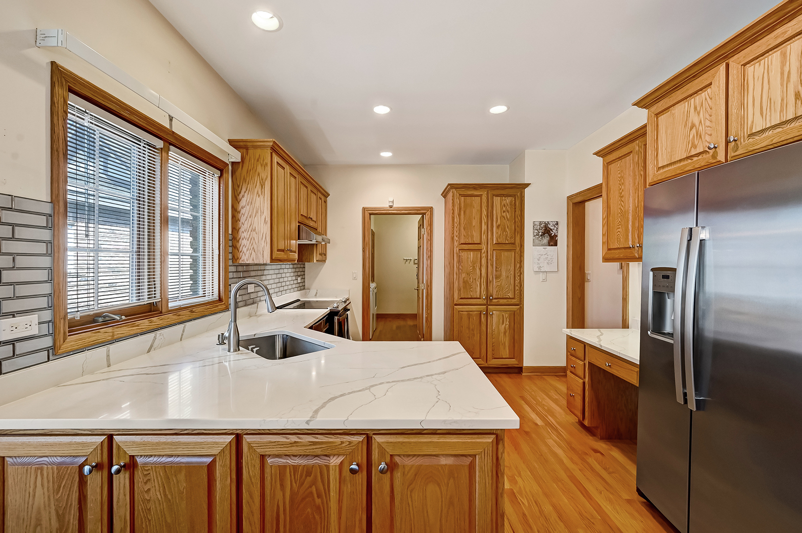 61 Berkshire Court Burr Ridge, IL 60527 - Photo 11 of 47 a kitchen with stainless steel appliances granite countertop a sink a refrigerator and wooden cabinets