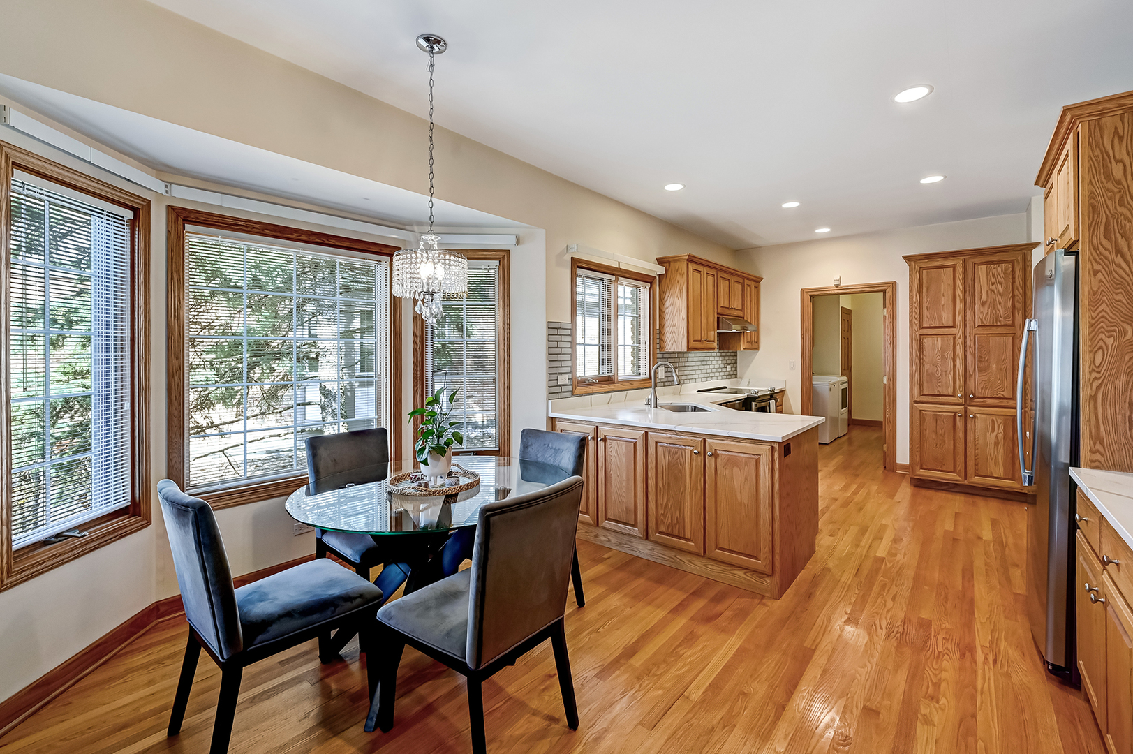 61 Berkshire Court Burr Ridge, IL 60527 - Photo 13 of 47 a kitchen with a refrigerator a sink dishwasher a dining table and chairs with wooden floor