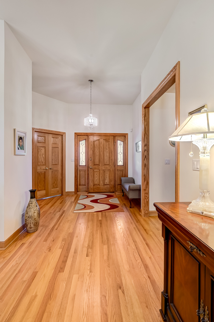 61 Berkshire Court Burr Ridge, IL 60527 - Photo 6 of 47 a spacious bedroom with a bed and a wooden floor