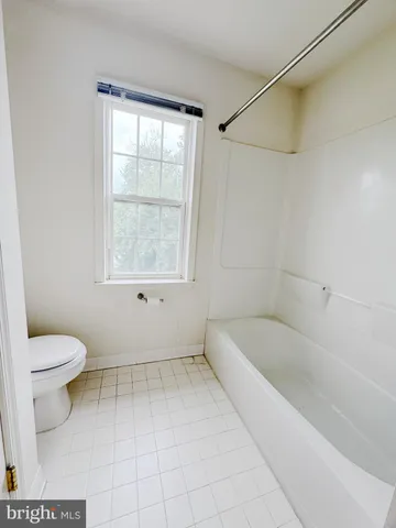a bath room with a toilet and a bath tub