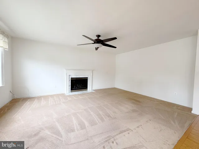 a view of a room with a ceiling fan and window