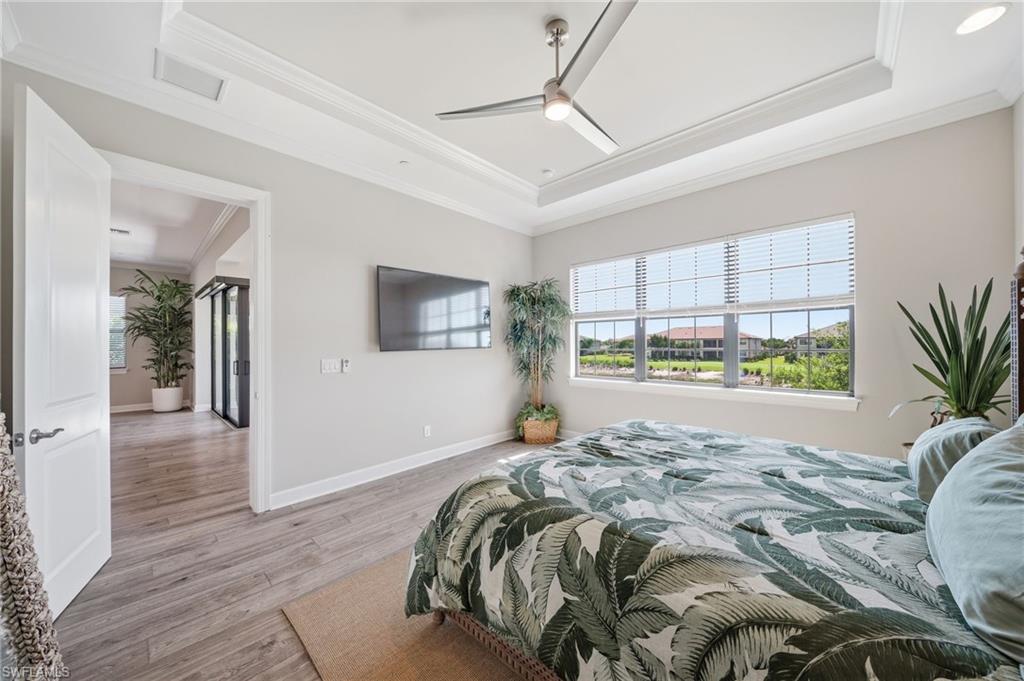 9658 Montelanico Loop, Unit 201 Naples, FL 34119 - Photo 16 of 46 a bed sitting in a spacious bedroom next to a window