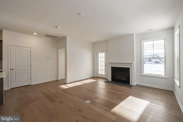 a view of an empty room with a window and fireplace