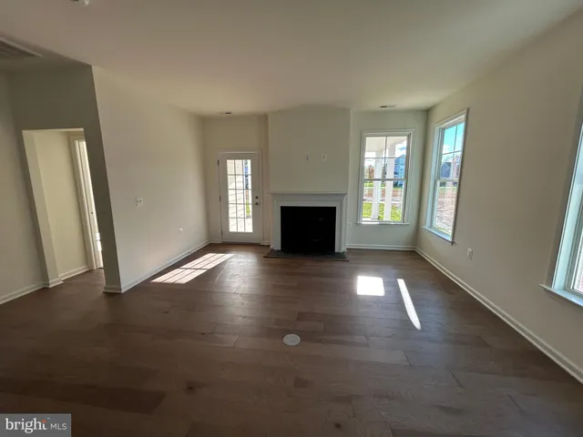an empty room with windows and fireplace