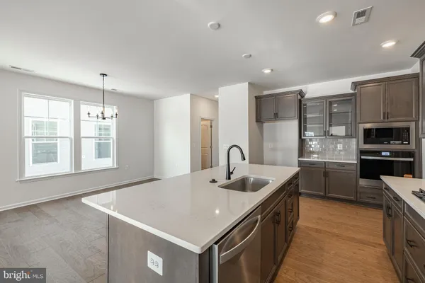 a kitchen with stainless steel appliances granite countertop a sink a oven a counter space and cabinets