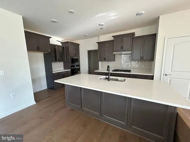 a kitchen with kitchen island a sink stainless steel appliances and cabinets