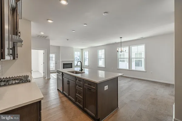 a kitchen with stainless steel appliances granite countertop a stove a sink dishwasher and a refrigerator with wooden floor