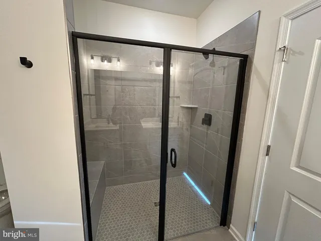 a bathroom with a glass shower door and a mirror