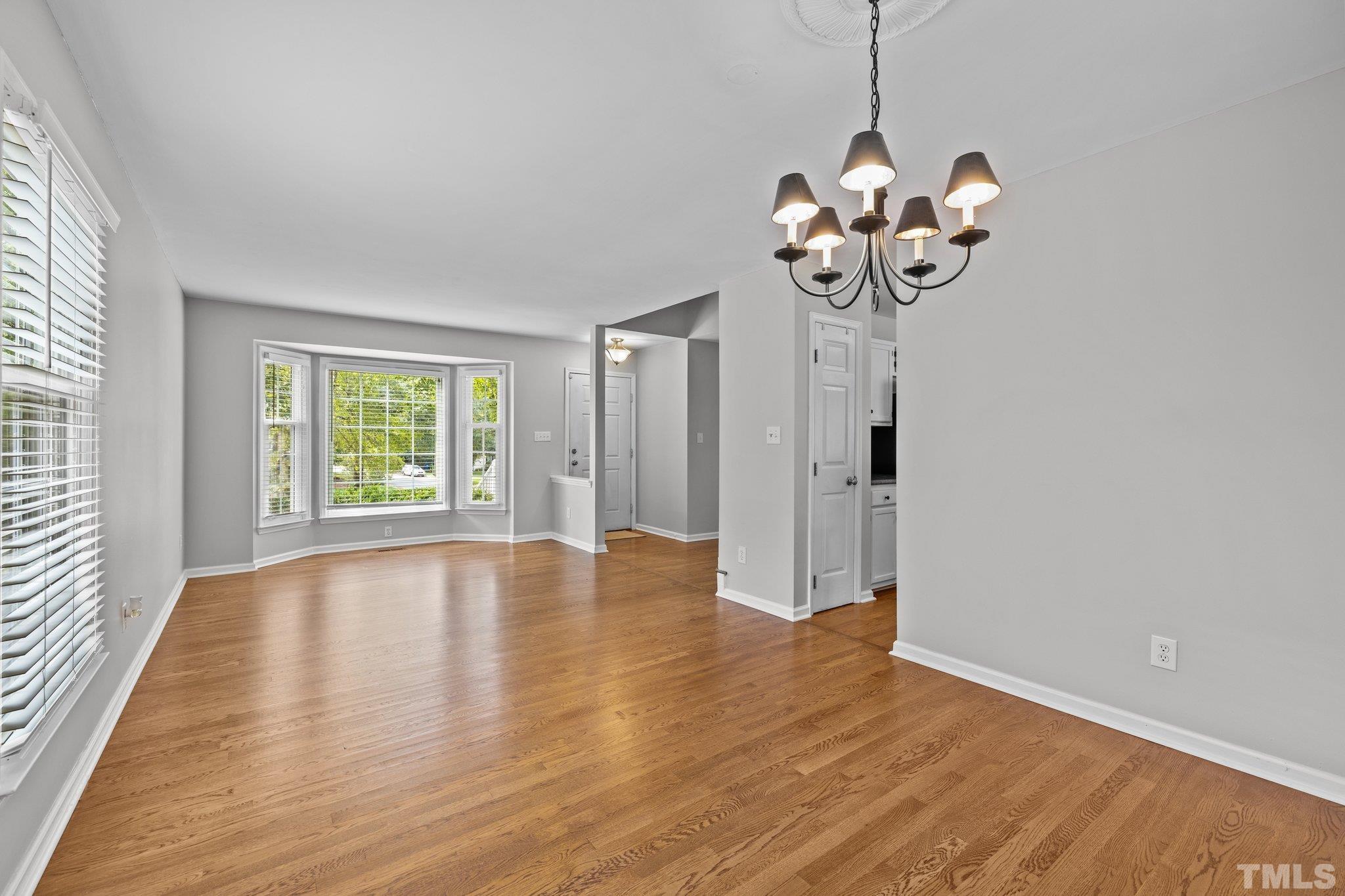 12028 North Exeter Way Raleigh, NC 27613 - Photo 11 of 48 a view of an empty room with wooden floor and a window