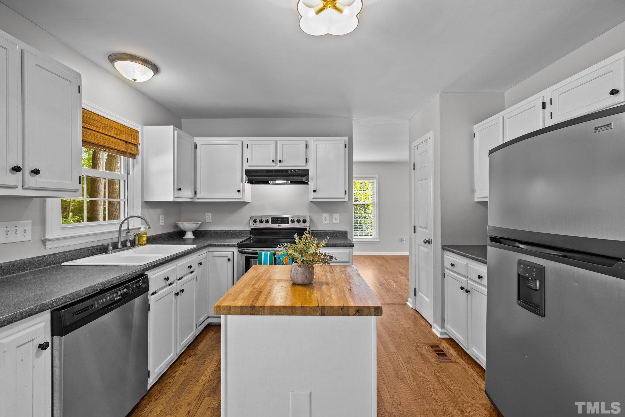 12028 North Exeter Way Raleigh, NC 27613 - Photo 15 of 48 a kitchen with stainless steel appliances a stove sink microwave and cabinets