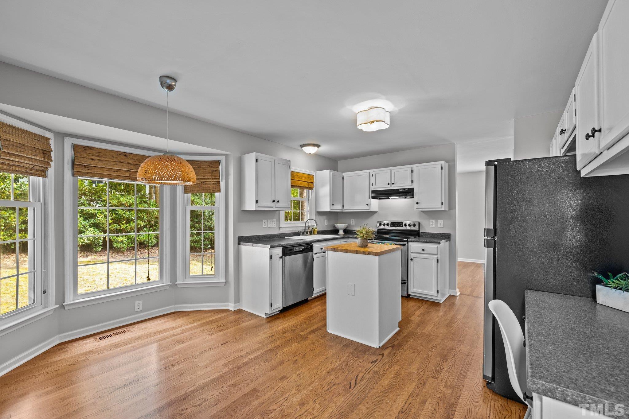12028 North Exeter Way Raleigh, NC 27613 - Photo 18 of 48 a kitchen with sink a refrigerator and wooden floor