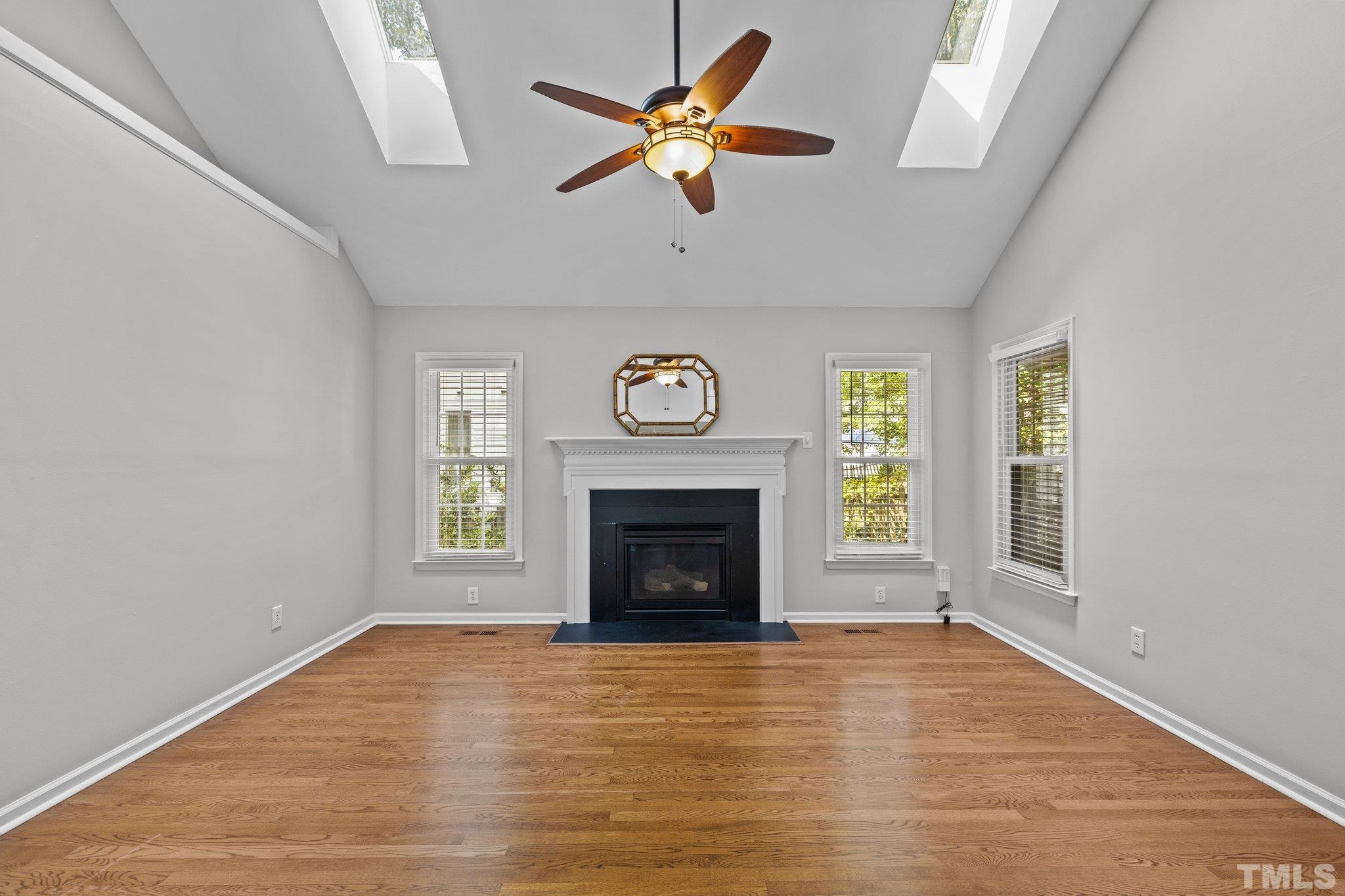 12028 North Exeter Way Raleigh, NC 27613 - Photo 20 of 48 a view of an empty room with a fireplace and a window