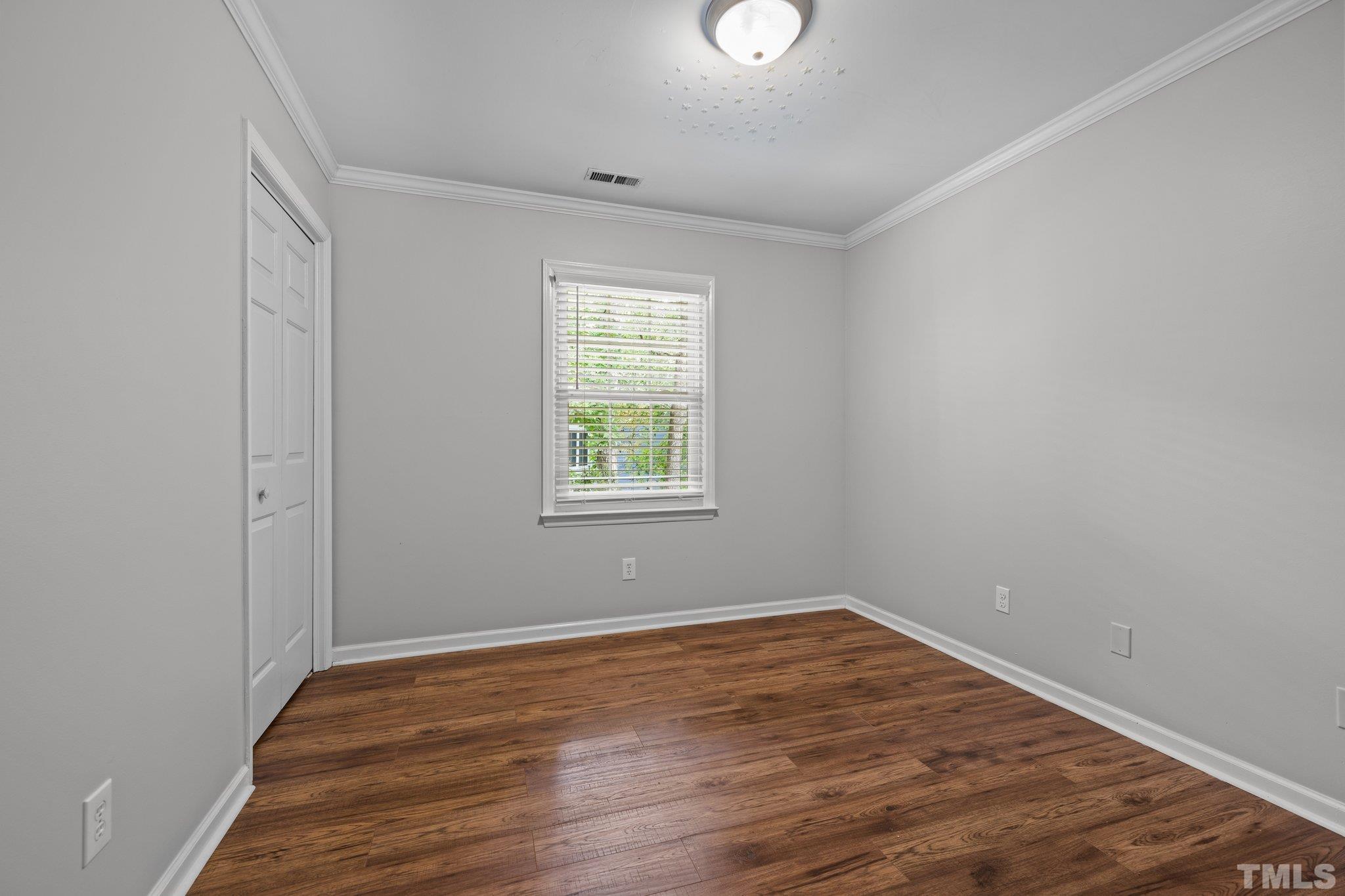 12028 North Exeter Way Raleigh, NC 27613 - Photo 34 of 48 an empty room with wooden floor and windows