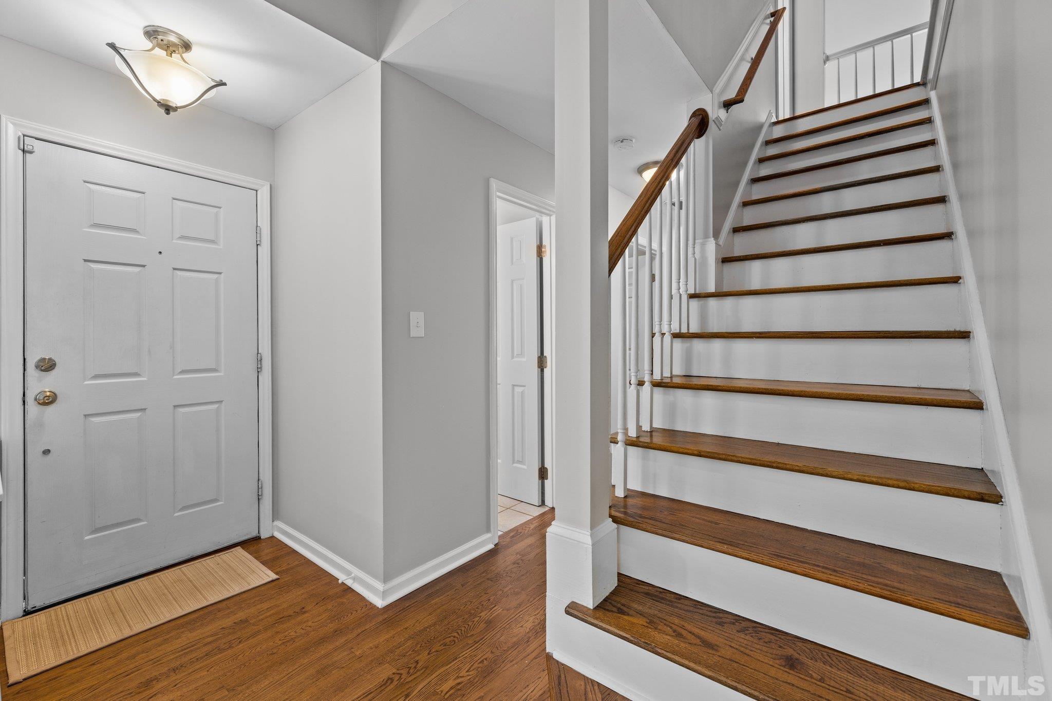 12028 North Exeter Way Raleigh, NC 27613 - Photo 9 of 48 a view of entryway with wooden floor and stairs
