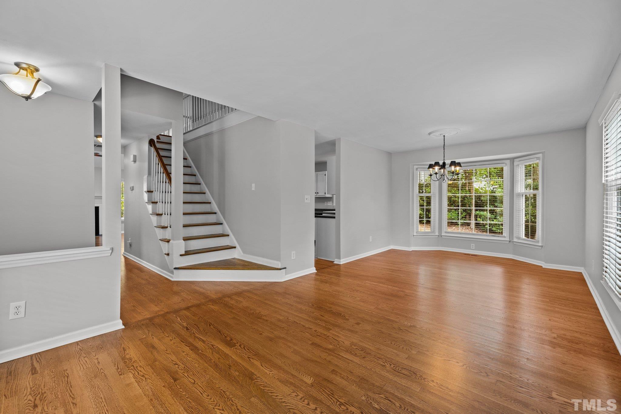 12028 North Exeter Way Raleigh, NC 27613 - Photo 10 of 48 a view of an empty room with wooden floor and a window
