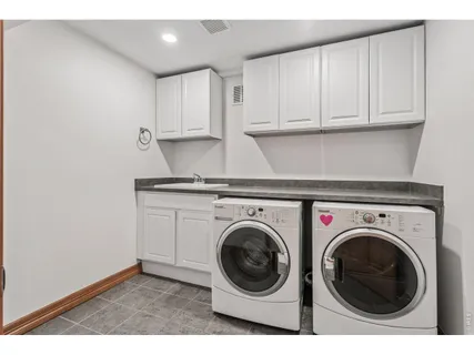a utility room with sink dryer and washer