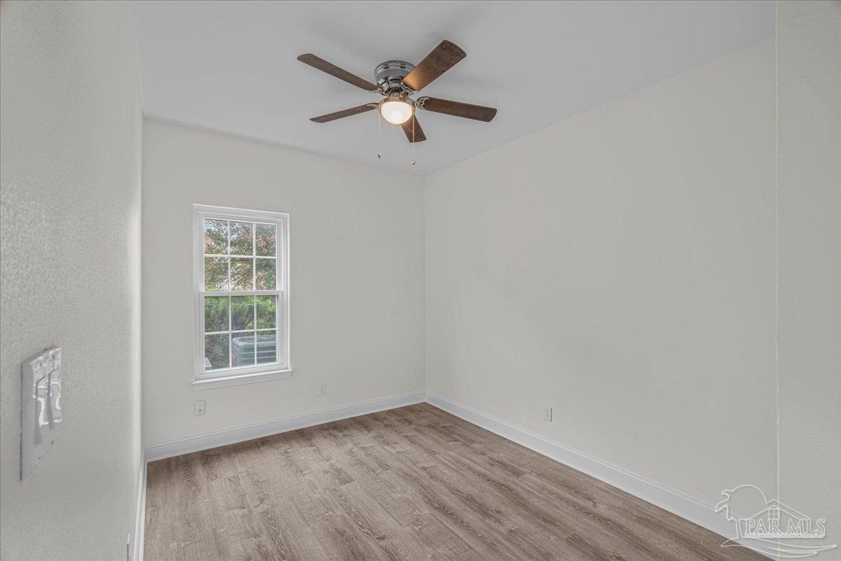 601 East Burgess Road, Unit C3 Pensacola, FL 32504 - Photo 20 of 35 an empty room with wooden floor fan and windows