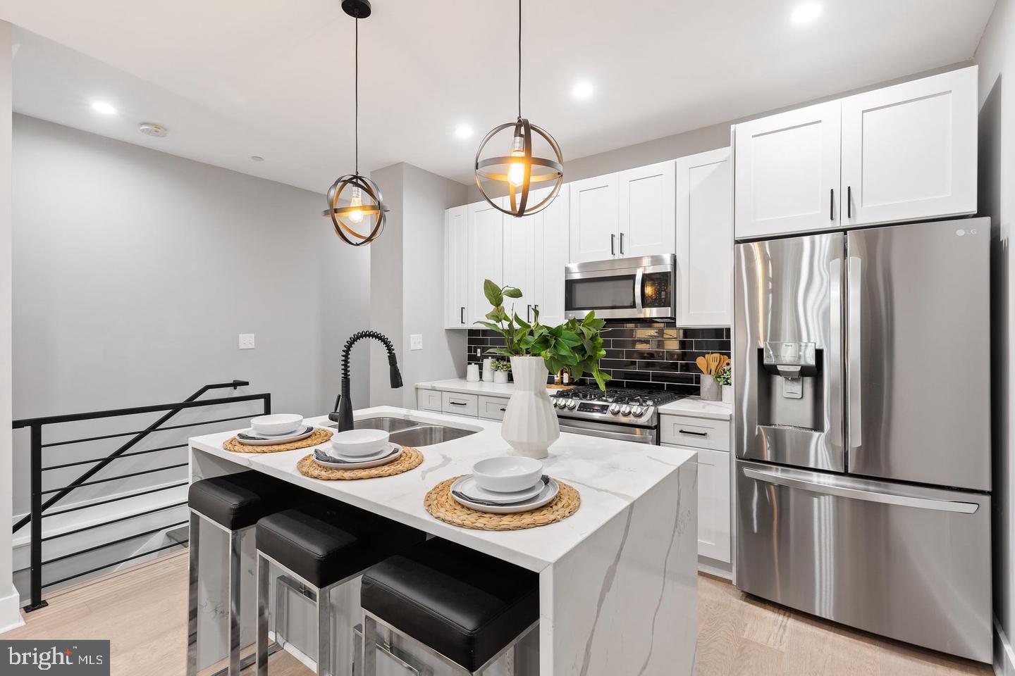 213 Bates Street Northwest, Unit 1 Washington, DC 20001 - Photo 4 of 28 a kitchen with stainless steel appliances granite countertop a sink a stove a refrigerator with a dining table and chairs