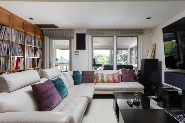 a living room with furniture a bookshelf and a large window