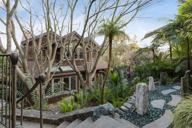 a front view of a house with a yard and fountain