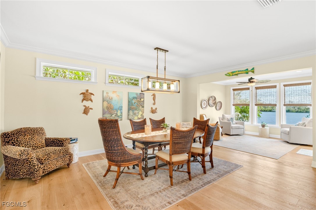 2391 Shop Road Sanibel, FL 33957 - Photo 11 of 50 a dining room with furniture a chandelier and wooden floor
