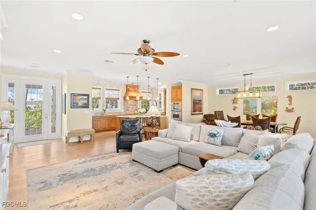 a living room with furniture kitchen view and a chandelier