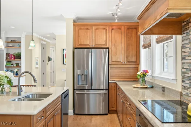 a kitchen with stainless steel appliances granite countertop a sink and a refrigerator