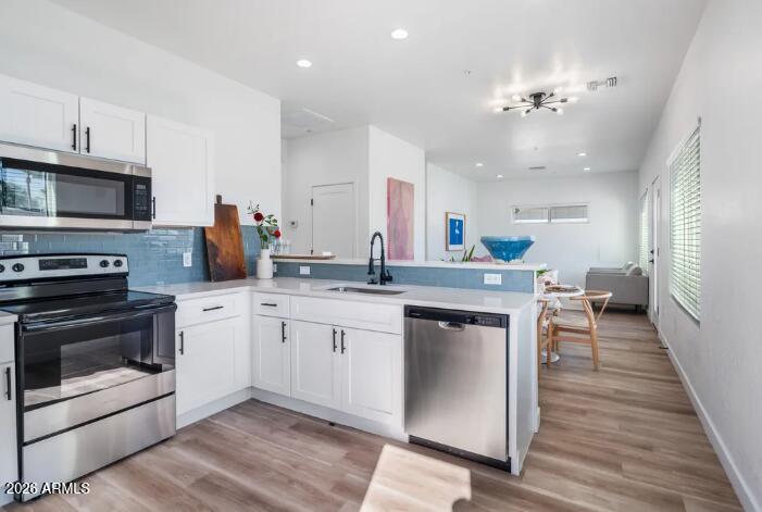 4202 North 10th Street, Unit 6 Phoenix, AZ 85014 - Photo 4 of 18 a kitchen with stainless steel appliances a stove sink microwave and cabinets