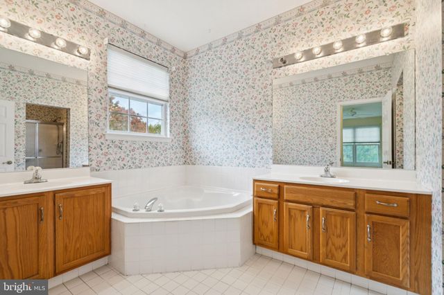 a bathroom with a tub a sink and a mirror