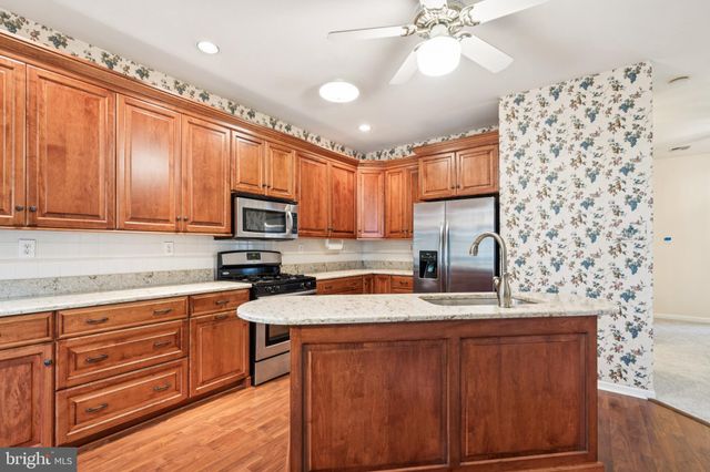 a kitchen with granite countertop a sink stainless steel appliances and cabinets