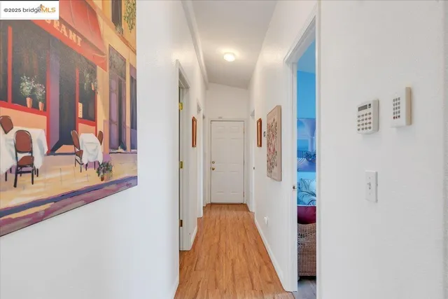 a view of a hallway with wooden floor and staircase
