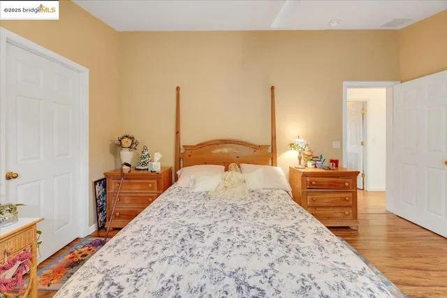 a bedroom with a bed and wooden floor