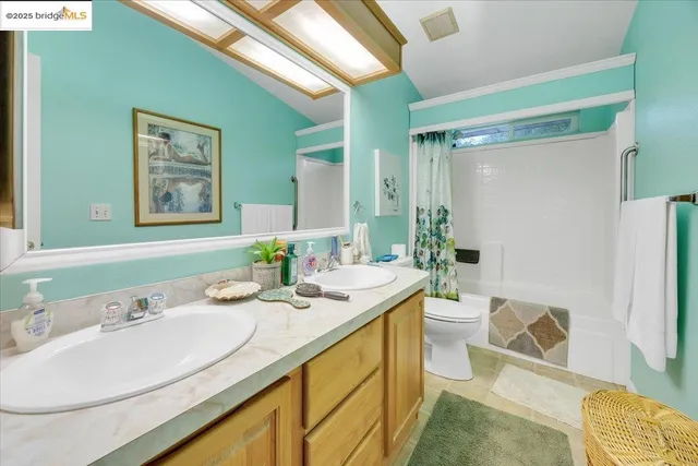 a bathroom with a granite countertop sink mirror vanity and toilet