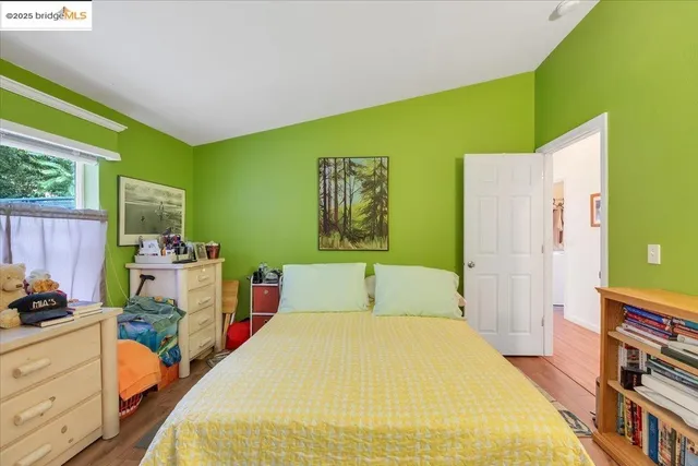 a bedroom with a bed and a computer on the dresser