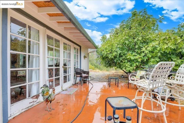 a view of a patio with a table and chairs and potted plants