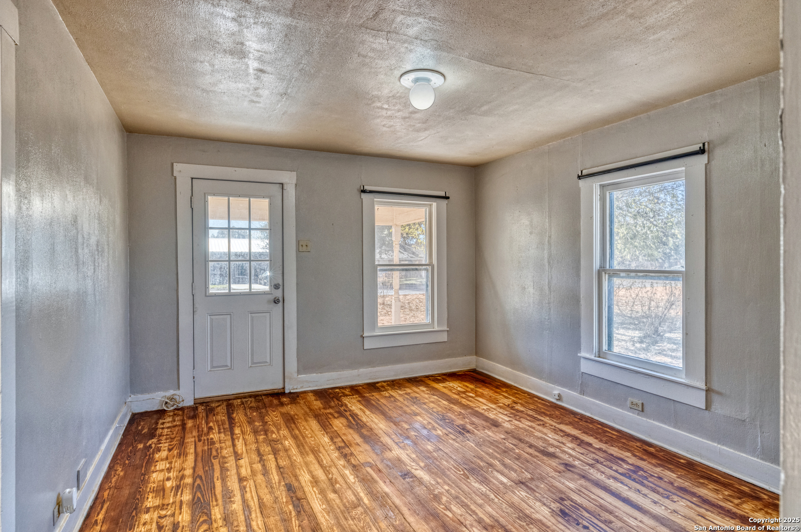 719 East Trinity Street Pearsall, TX 78061 - Photo 16 of 26 a view of empty room with wooden floor and fan