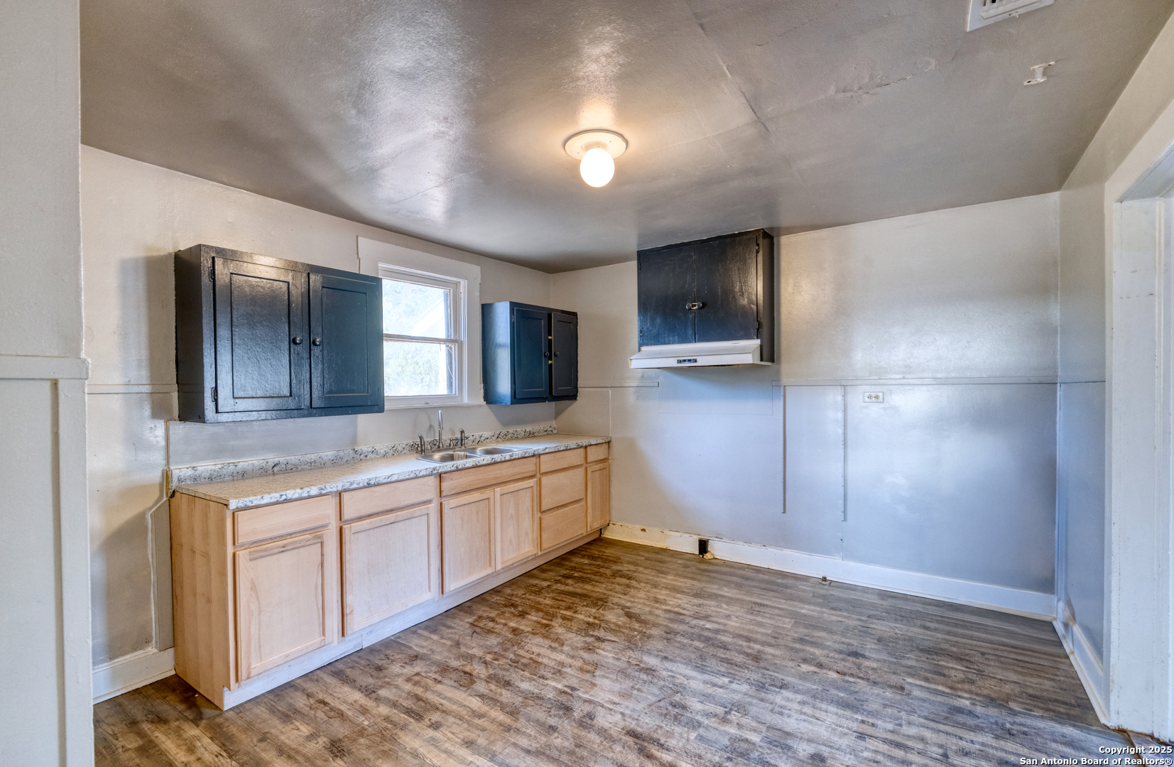 719 East Trinity Street Pearsall, TX 78061 - Photo 17 of 26 a kitchen with stainless steel appliances granite countertop a sink and cabinets