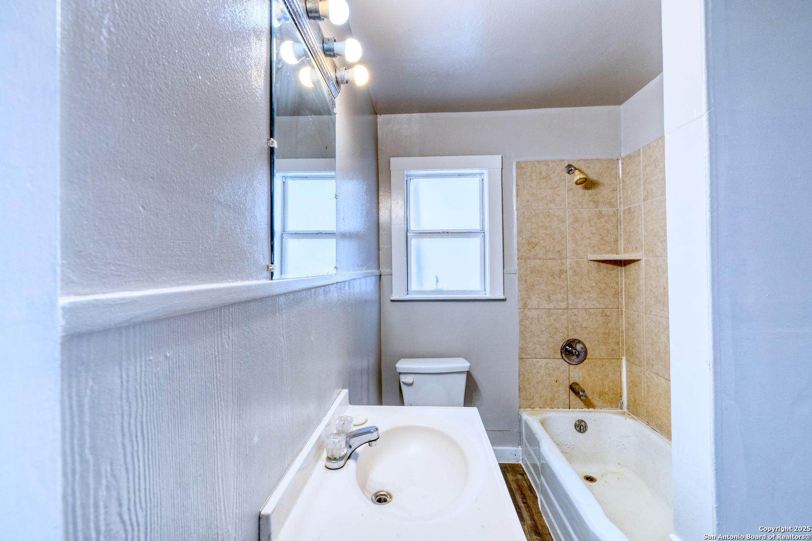 719 East Trinity Street Pearsall, TX 78061 - Photo 19 of 26 a bathroom with a tub sink and mirror