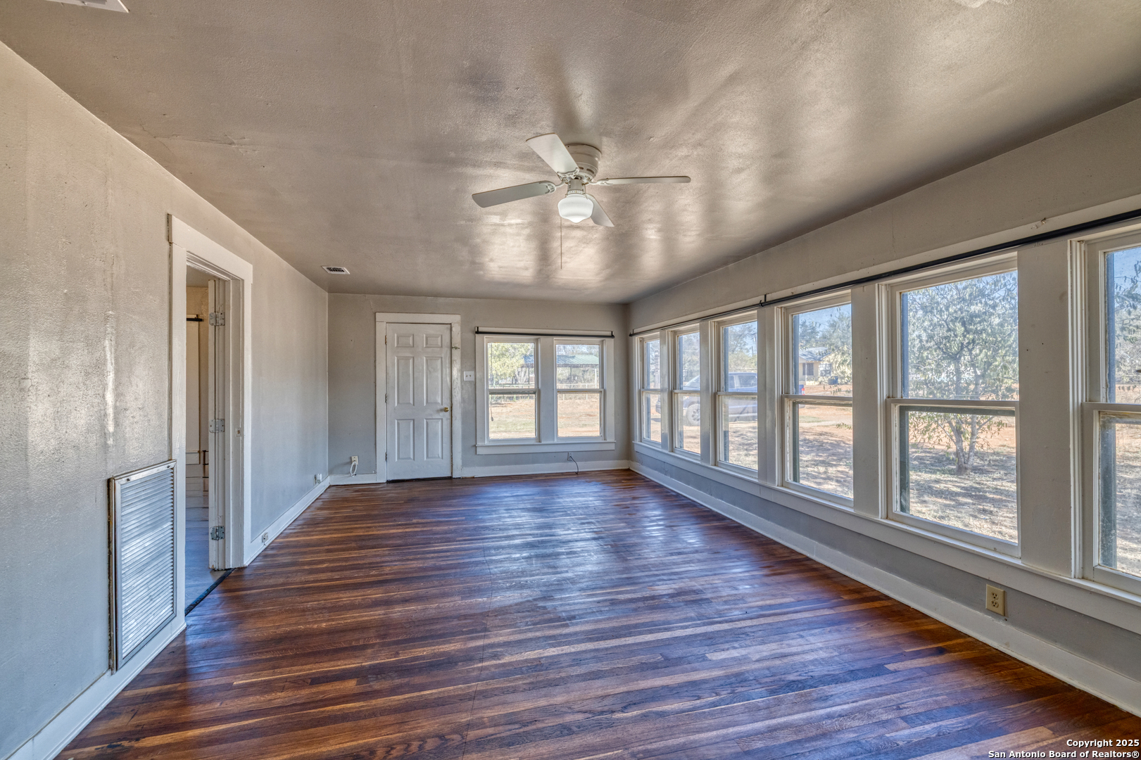 719 East Trinity Street Pearsall, TX 78061 - Photo 22 of 26 a view of an empty room with wooden floor and a window