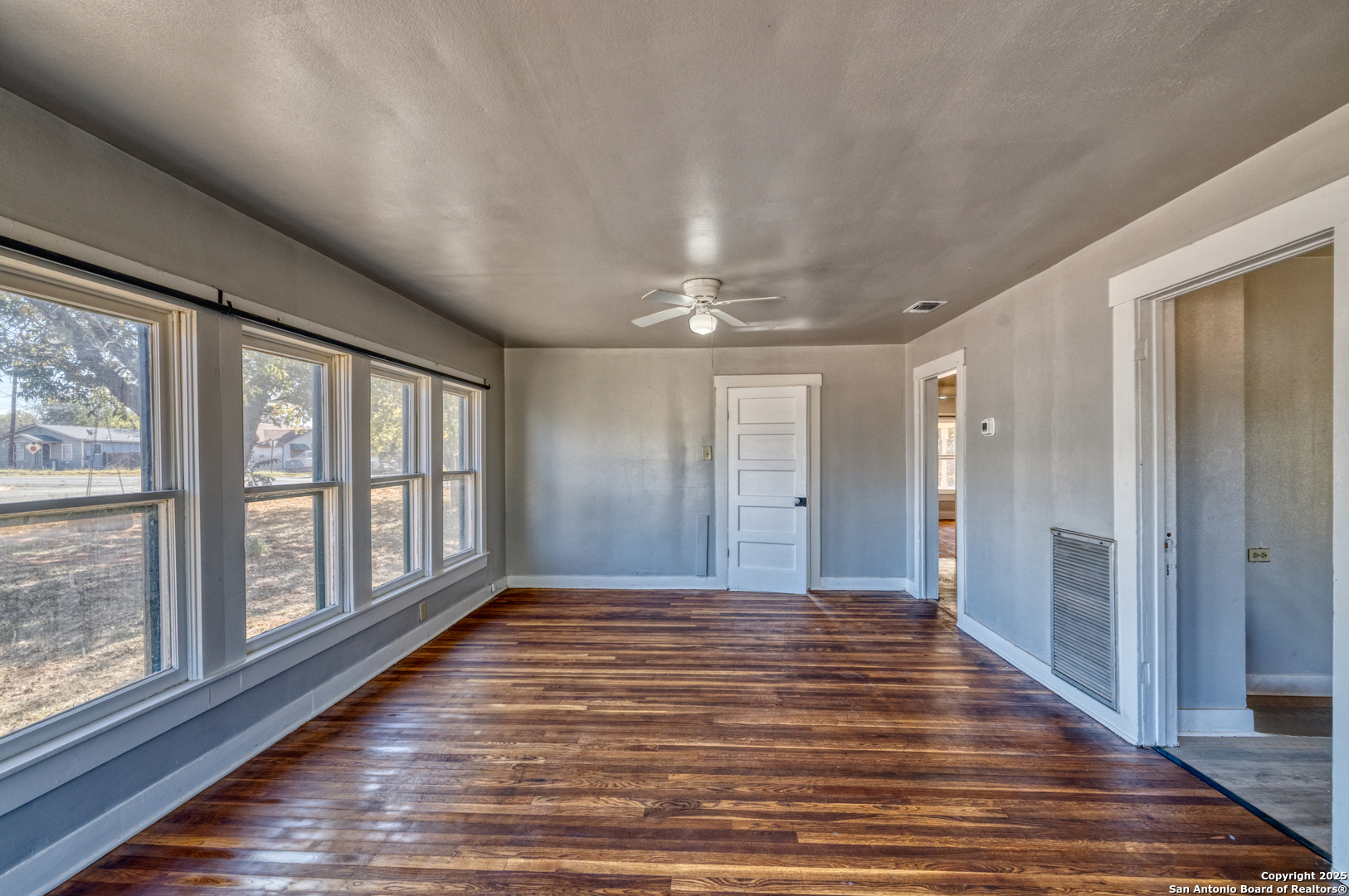 719 East Trinity Street Pearsall, TX 78061 - Photo 23 of 26 a view of a hallway with wooden floor and windows